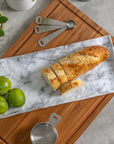 Merritt Designs White Marble 15.25 inch Rectangle Melamine Appetizer Tray with a wonderful loaf of fresh bread