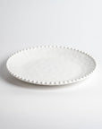 Cream colored, 11-inch melamine dinner plate with beaded rim, front view