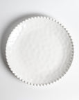 Cream colored, 11-inch melamine dinner plate with beaded rim, top view