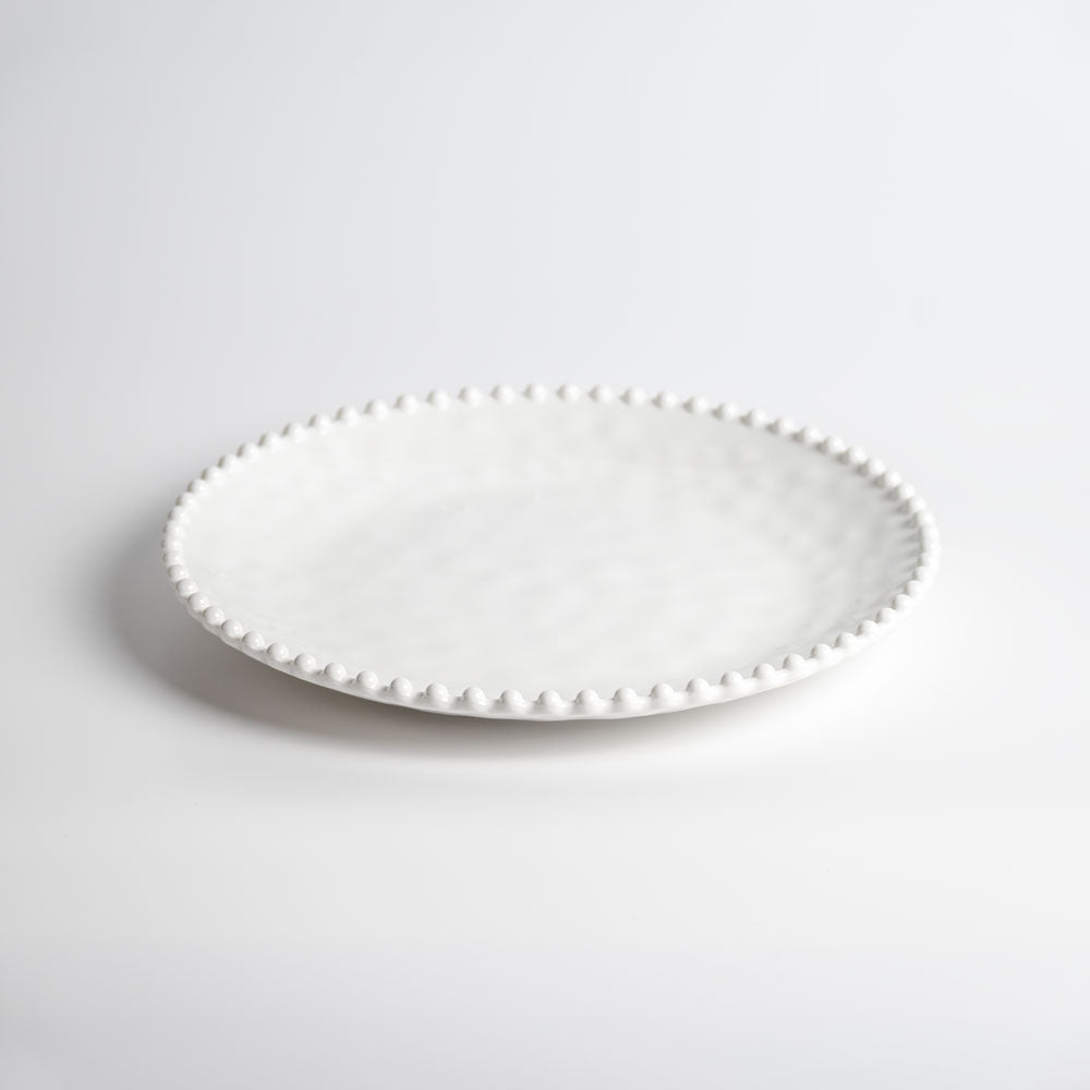 Cream colored, 11-inch melamine dinner plate with beaded rim, front view