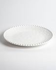 Cream colored, 11-inch melamine dinner plate with beaded rim, front view