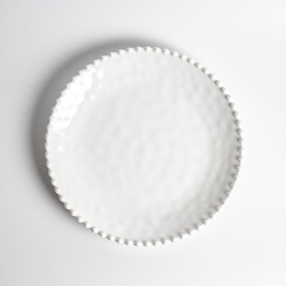 Cream colored, 11-inch melamine dinner plate with beaded rim, top view
